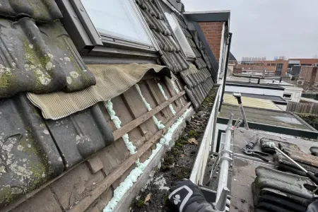 Dakreparatie op woning met gereedschap en steiger.